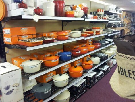 A shelf full of pots and pans in a store.