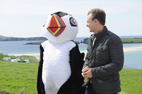 Amazing Race host Phil Keogan with a puffin mascot at St Ninian's Isle. Photo: Heather Wines/CBS
