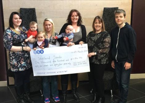 Marie Manson of Shetland Sands (right with her son William) is accepting the donation from Nicola Bowie with Rylee, Amy Gerrard with Lucy and Jennifer Munro with Magnus.