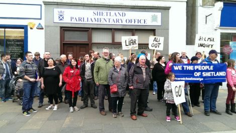 Protesters gather outside Alistair Carmichael's constituency office on Saturday afternoon to call for his resignation. Photo Shetnews