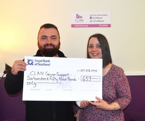 Walk organiser Adam Grzyb presenting money to CLAN Cancer Support's Shetland co-ordinator Dana Millarkie.