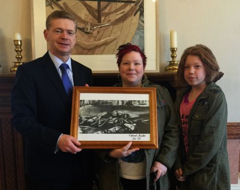 Council convener Malcolm Bell accepts the artwork from Shetland Supports Refugees founder Wendy Sinclair (centre) and her daughter Lainey Sinclair (right).