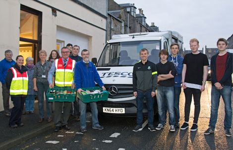 David Grieve of Shetland Foodbank and Tesco store manager Neil Connell (centre) with local volunteers from Inside Connections, Lerwick Celtic, Lerwick Community Council and Islesburgh Drama Group at the St Magnus Street foodbank on Monday.