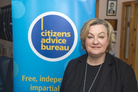 Woman standing in front of a citizens advice bureau banner.