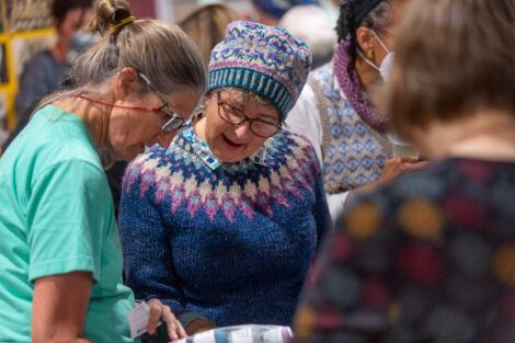 A group of women talking to each other at a craft fair.