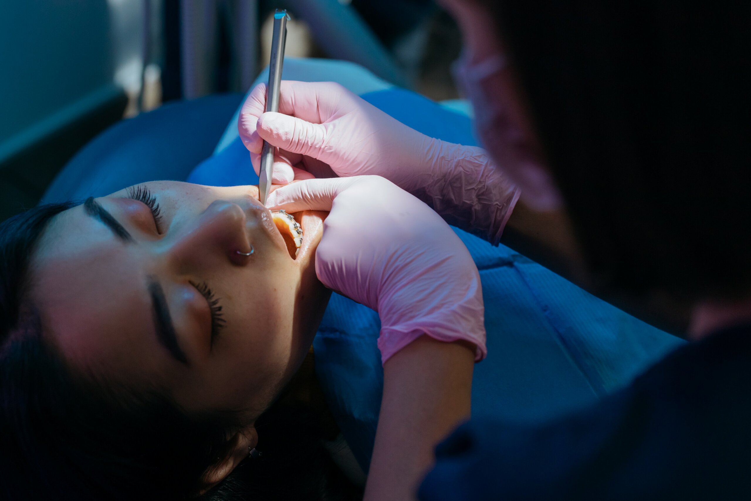 Dental examination in progress with a patient reclining as a dentist performs a check-up.