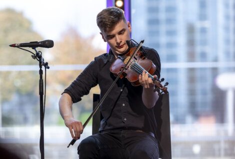 A violinist performing on stage with focus and intensity.