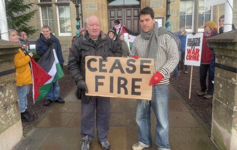 A man holding a sign that says case fire in front of a building.