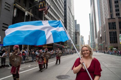 A woman holding a scottish flag.
