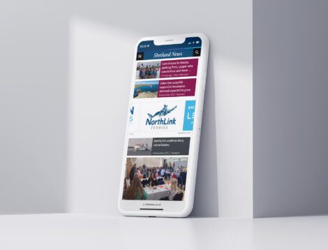 A mobile phone with the Shetland News displayed on it.