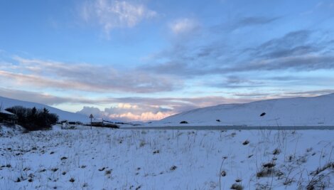 A snow covered field with mountains in the background.