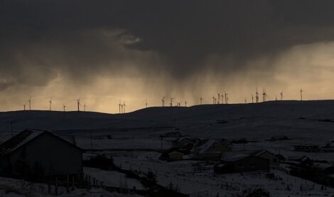 A stormy sky with wind turbines in the background.