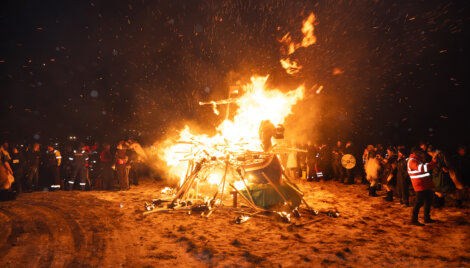 A large bonfire with people around it.