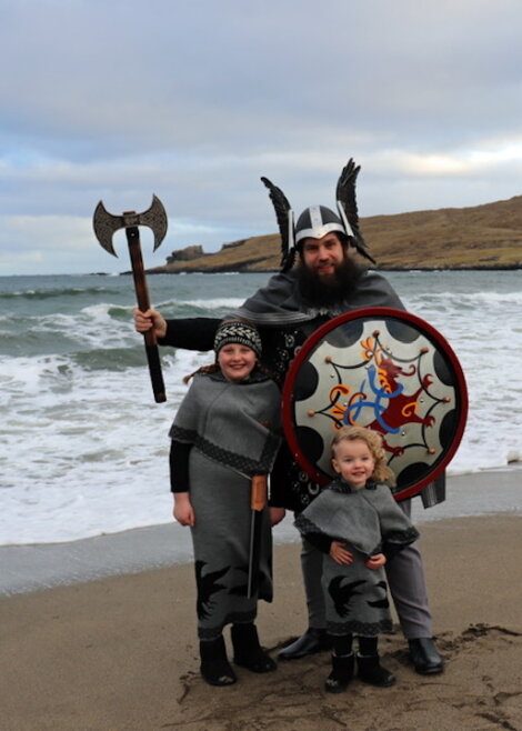 A family dressed up as vikings on the beach.